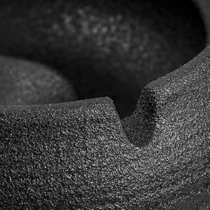 Photographie macro très rapprochée montrant une surface texturée foncée avec une empreinte incurvée, probablement en mousse ou en caoutchouc, avec une texture granuleuse visible.